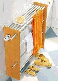 there is a towel rack in the bathroom with yellow slippers on the floor next to it