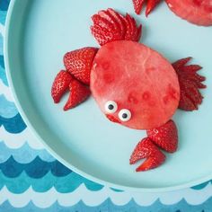 a plate that has some food on it with strawberries in the shape of a fish