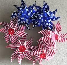 a patriotic wreath with red, white and blue pinwheels hanging on the wall