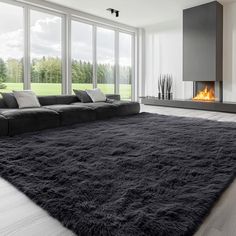 a living room with a large black rug on the floor next to a fire place