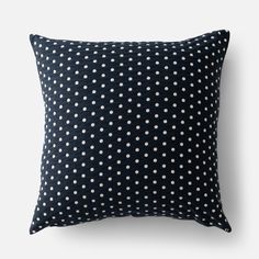 a black pillow with white polka dots on it