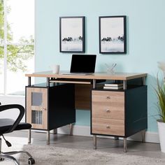 a desk with a laptop on it in front of a blue wall and potted plant