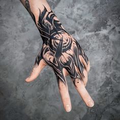 a man's hand with tattoos on it