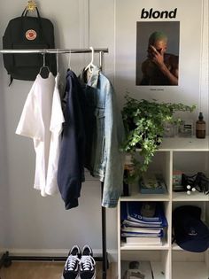 a room with clothes and shoes hanging on a rack