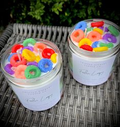 two jars filled with jelly beans sitting on top of a wicker table next to each other