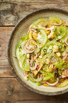 a bowl filled with vegetables on top of a wooden table