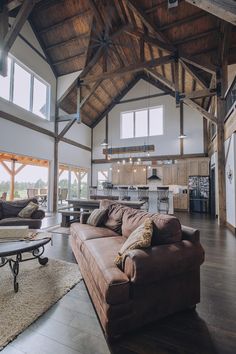 a large open living room with high ceilings and wooden beams on the ceiling is filled with furniture