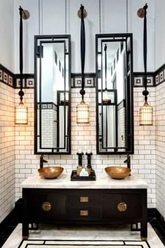 a bathroom with two sinks, mirrors and lights on the wall above them is black and white tile