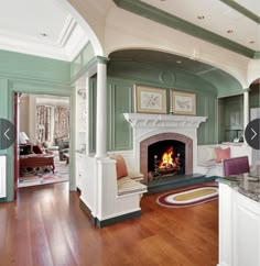 a living room filled with furniture and a fire place in the middle of a kitchen