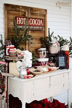 an american farmhouse style christmas display in front of a wooden sign with hot cocoa on it