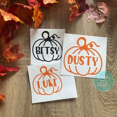 three pumpkin stencils sitting on top of some autumn leaves and one is orange