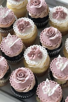 there are many cupcakes that have pink and white frosting on them