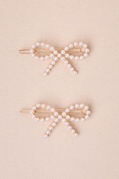 The Lulus Sincere Charm White Pearl Bow Hair Clip Set is the easiest way to look lovely in an instant! This coquette-inspired hair accessory set features two, gold-toned bows, embellished with gleaming white faux pearls, all atop barrette-style clips. However you style these cute clips, they are sure to make any 'fit extra adorable! Hair Clip Measures 1. 50" Long And 2" Wide. 60% Pearl, 20% Casted, 20% Iron. Imported. Lulus | Sincere Charm White Pearl Bow Hair Clip Set. Cute White Hair Accessories, Bow Hair Tie, Hair Bow Clip, Pink Bow Accessories, Cute Hair Accessories, White Hair Accessories With Decorative Bow For Summer, White Bow Hair Accessories As Gift, Pearl Hair Bow, White Decorative Bow Hair Accessories For Summer