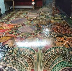 an artisticly designed floor in a restaurant or bar with colorful tiles on the floor