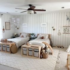 two twin beds in a bedroom with striped walls and white carpeted flooring, along with toy storage bins