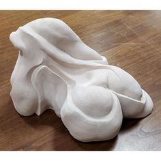 a white sculpture sitting on top of a wooden floor