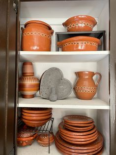 the shelves are filled with different types of pottery