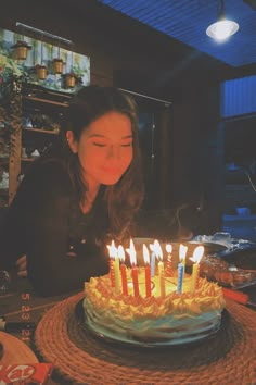 a woman blowing out candles on a birthday cake