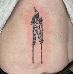 a woman's lower back tattoo with an image of a man holding a cane