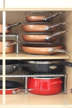 pots and pans are stacked on top of each other in the kitchen cabinet drawer