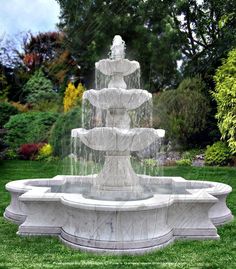 a water fountain in the middle of a grassy area