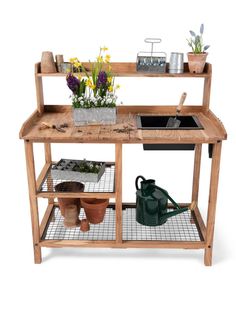 a wooden workbench with pots and plants on it's shelves, including watering tools