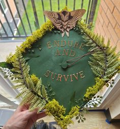 someone holding up a green graduation cap that says,'endure and survive '