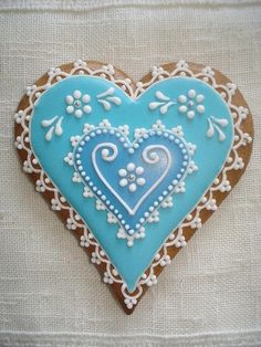 a heart shaped cookie decorated with blue icing