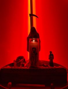 a red light room with a lit candle and star wars figurines on the table