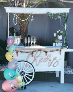 an ice cream cart decorated with balloons and confetti for a birthday or baby shower