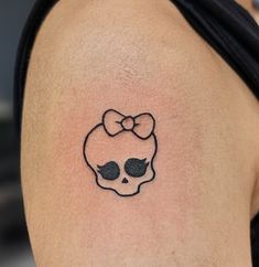 a skull with a bow tattoo on the back of it's shoulder and behind its ear