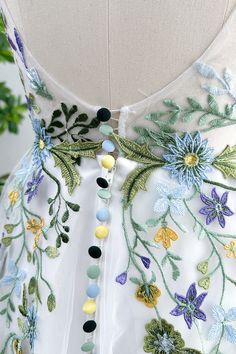 the back of a dress with flowers and leaves embroidered on it's waistline