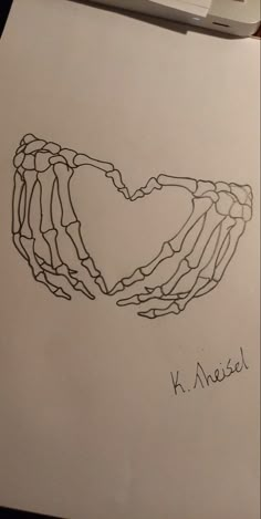 a drawing of two hands in the shape of a heart on top of a piece of paper