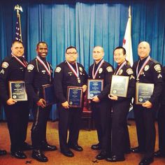 five men in uniform holding plaques and flags