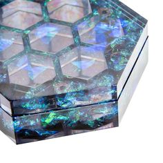 a glass box that has some kind of design on it's lid and is covered in iridescent colors