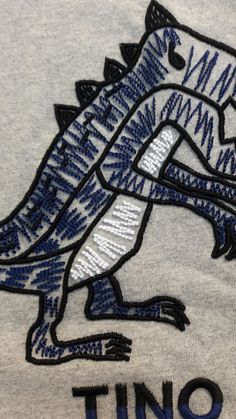 a blue and white t - shirt with the word dino on it