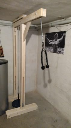 a gym room with an overhead pull up bar and metal trash can in the corner