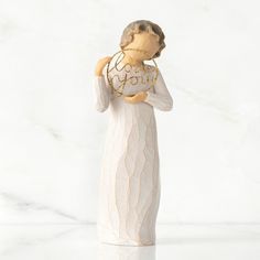 a ceramic figurine with a white dress and gold bead around her neck