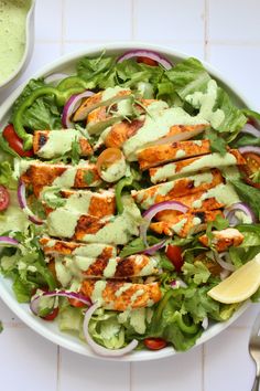 a salad with chicken, lettuce and tomatoes