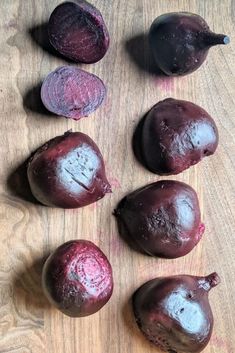 several pieces of beet sitting on top of a wooden table next to an eggplant