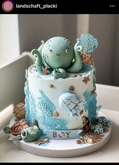 a blue and white cake with an octopus in the ocean on it's side