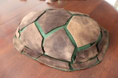 a brown and green hat sitting on top of a wooden table