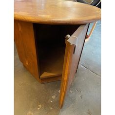 a wooden table with an open drawer on it's side in a garage area