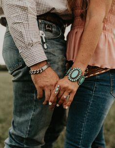 two people standing next to each other holding hands