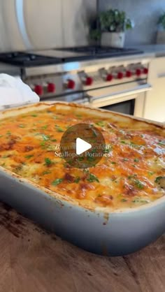 a large casserole dish sitting on top of a wooden counter next to an oven