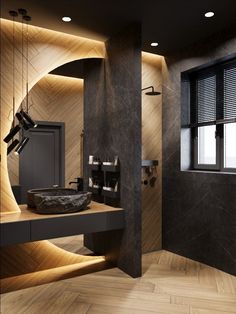 a modern bathroom with wood flooring and black walls, along with a stone sink