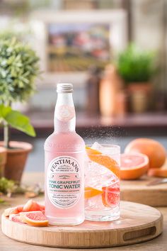 a bottle of pink grapefruit water sitting on top of a wooden cutting board