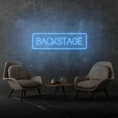 two chairs and a table in front of a green wall with the words backstage on it