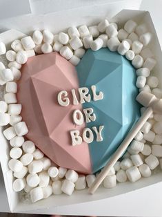 a cake with marshmallows in the shape of a heart and girl or boy on it