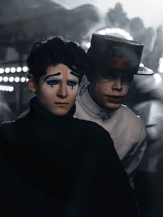 two people with black and white make up on their faces